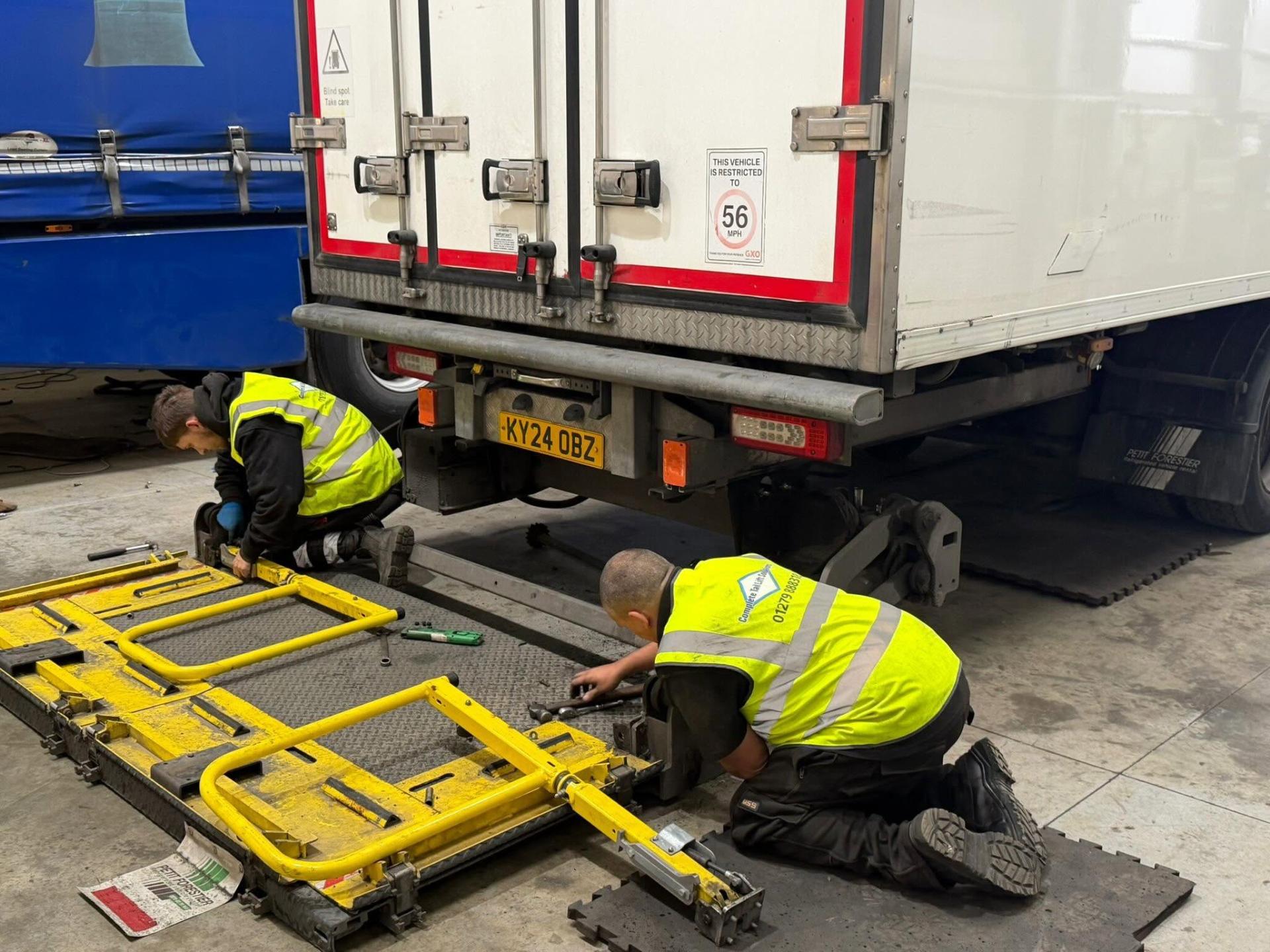 Complete Tail Lift Solutions engineers repairing a hydraulic tail lift on a commercial vehicle